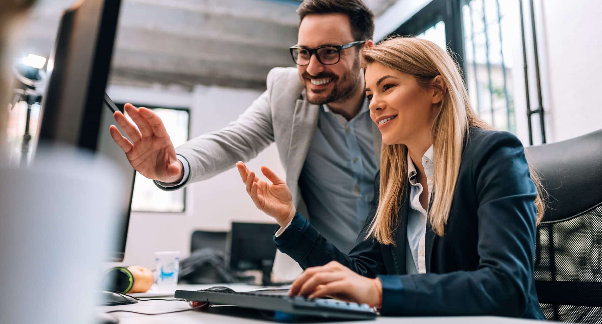 Working together on project. Two young business colleagues working on computer